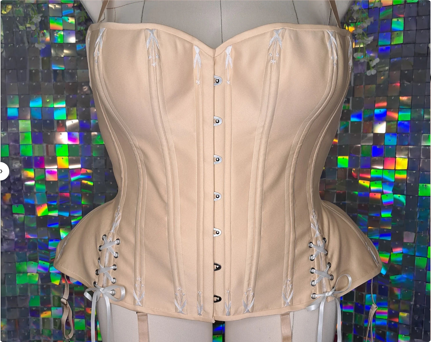 Nude glossy satin overbust corset with busk, lace-up hip gores and flossing embroidery — the finished corset