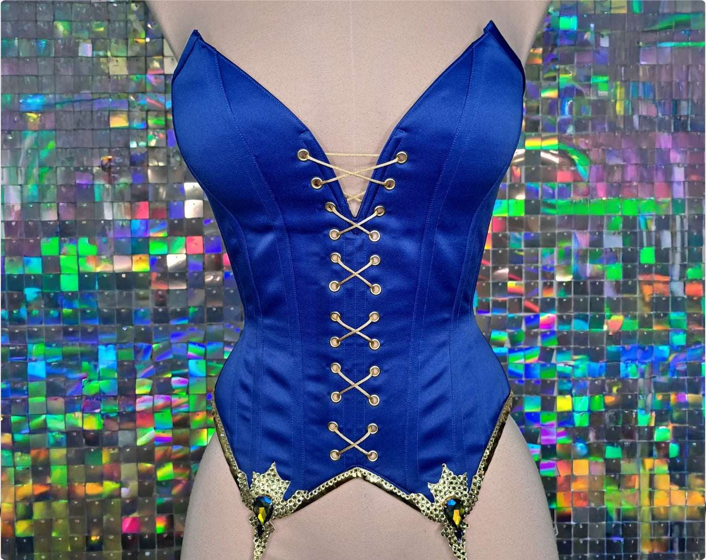 Glossy indigo satin overbust corset with solid front, decorative front lacing and rhinestone applique on contrasting golden denim bias tape — the finished corset
