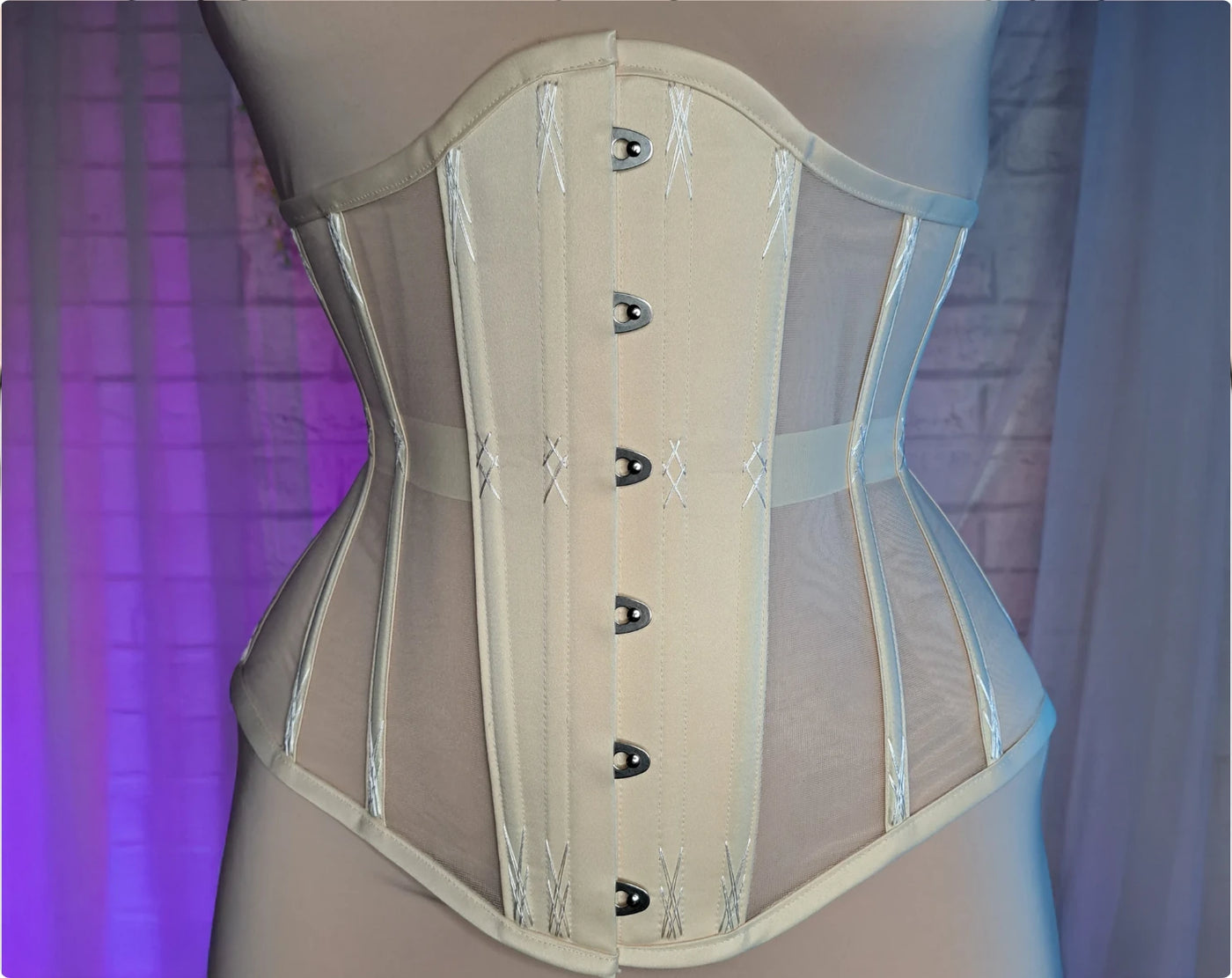 Nude nylon mesh underbust corset with busk, butterfly lacing and flossing embroidery — the finished corset